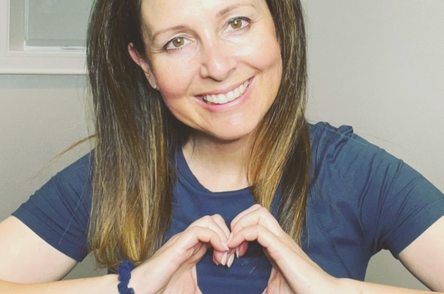 Nara, Calm Elements customer, holding a heart sign while smiling
